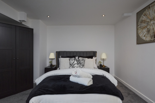 Sleep easy in this spacious double bedroom with soft linens and a relaxing ambience.