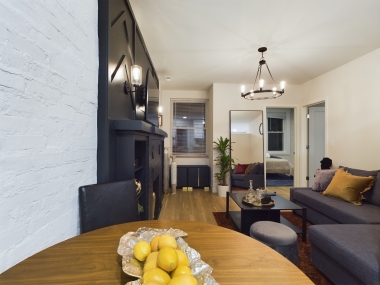 Cozy and chic, this dining area is perfect for enjoying a meal or a morning coffee. Set against a sleek black accent wall and adjacent to a charming fireplace blends comfort with sophistication, creating a warm and inviting atmosphere for your stay.