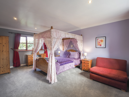 Large bedroom with king size four poster bed
