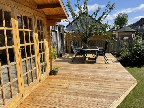 Log Cabin with suite and dining table in rear garden