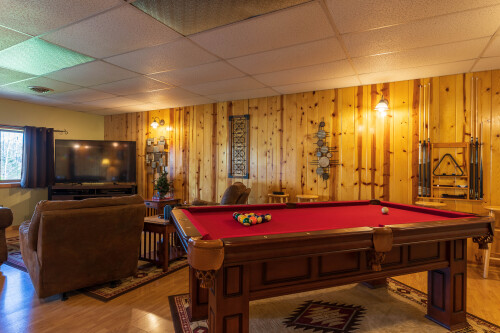 The lower level has both a pool table and large tv with comfy seating.