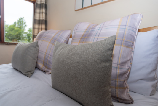 Inviting king-size bedroom with soft furnishings, bedside lighting and tranquil views across the surrounding countryside.
