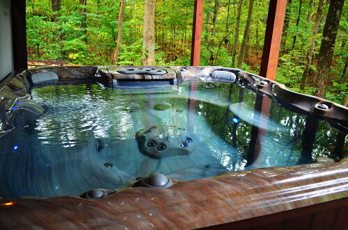 Outside relax and unwind in our high-end Sundance Hot Tub with waterfall and LED mood lighting