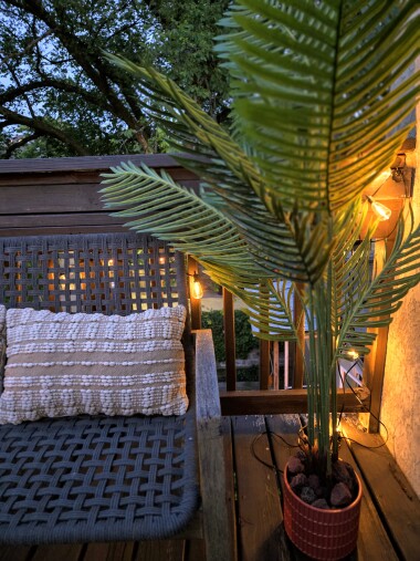 Soft lighting transforms the balcony into a cozy nighttime hideaway.