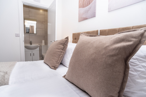 Master bedroom with zip-link beds that convert from two singles into a king, complete with private en suite — offering ultimate flexibility for any group