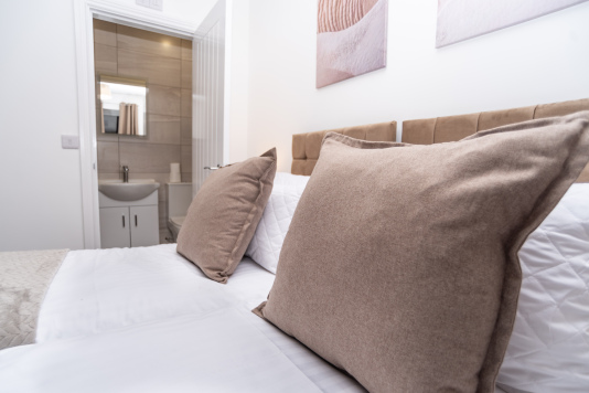 Master bedroom with zip-link beds that convert from two singles into a king, complete with private en suite — offering ultimate flexibility for any group