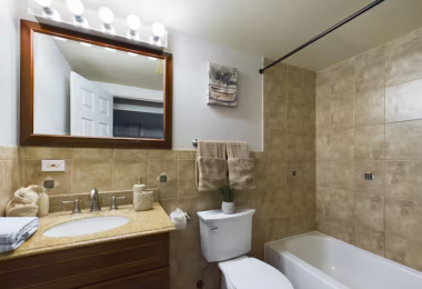 Refresh in this bright, well-appointed bathroom featuring a full tub and shower, warm tile accents, and a sleek vanity with ample counter space. Soft towels and thoughtful touches make it a spa-like retreat.
