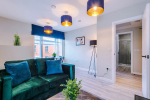Spacious living room with comfortable seating and inviting atmosphere, perfect for relaxing or socialising during your stay.