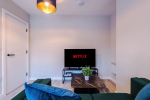 Spacious living room with comfortable seating and inviting atmosphere, perfect for relaxing or socialising during your stay.