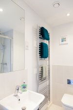 The master bedroom features an en-suite which is equipped with a heated towel rail, a large shower and some characterful little wall pictures.