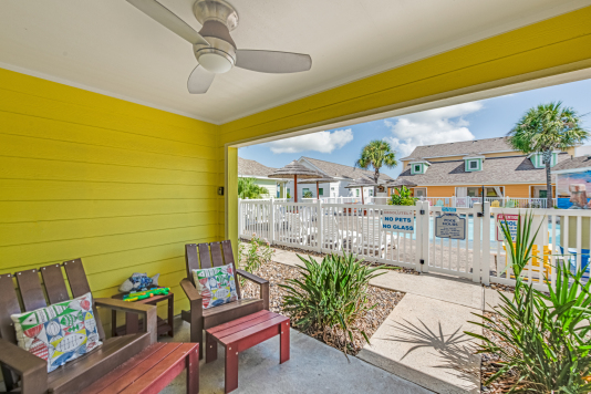 Patio has ceiling fan, there is a hose with spray and hooks for towels