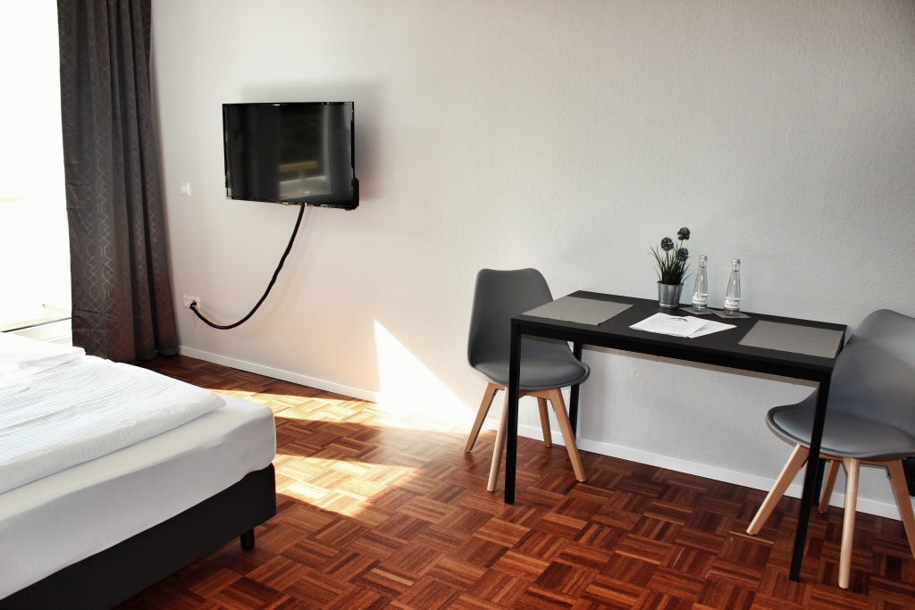 Wohn- und Schlafbereich mit Doppelbett und Esstisch