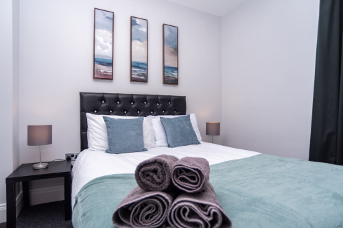 Spacious, welcoming bedroom with tasteful artwork, super-comfy mattresses, and soft bedding for a restful night’s sleep.