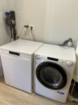 cellier équipé : lave vaisselle, machine à laver séchante et aspirateur Dyson.