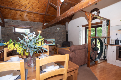 Dining, Living & 300 Years of History — All in One Room - Dining for six, a generous living space and the iconic mill wheel, all bathed in natural light under a vaulted ceiling