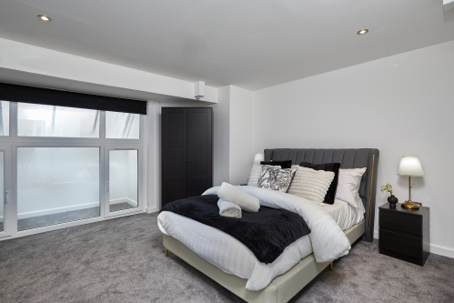 Settle into this serene double bedroom — a peaceful space to recharge.