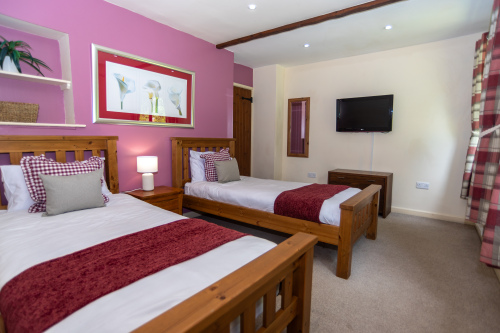 Two singles, a Smart TV and a cheerful pink feature wall - ready for kids or friends, with seperate downstairs shower room, for those with mobility concerns