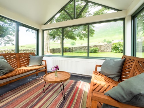 Large conservatory room offering sweeping view of Black Comb fell