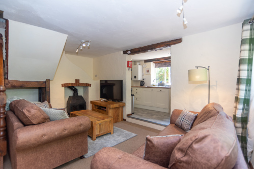 Unwind beside the wood burner in the comfortable living area, perfect for cosy evenings after coastal adventures.