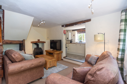 Unwind beside the wood burner in the comfortable living area, perfect for cosy evenings after coastal adventures.