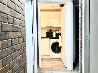 Kitchen with: toaster, Airfryer, kettle, slow cooker, chopping board, mugs, drinking glasses, cutlery, paper towels