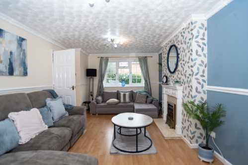 A recently refurbished, tastefully decorated living room with a large reclining sofa, sofa bed and a full HD Smart TV.