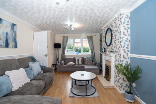 A recently refurbished, tastefully decorated living room with a large reclining sofa, sofa bed and a full HD Smart TV.