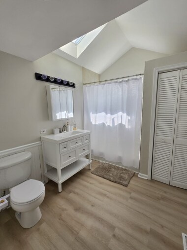 This spacious bathroom features a sleek vanity, a full bathtub for soaking, and vaulted ceilings with skylights, creating a bright and airy atmosphere. Ideal for unwinding and refreshing during your stay.