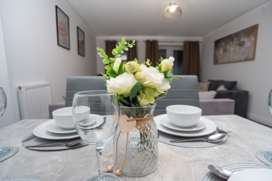 Spacious dining table fully set with cutlery, crockery and all essentials — perfect for shared meals or work sessions.