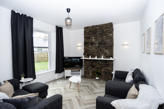 Spacious Living Room - Ample comfy seating, side tables, coffee table, full smart TV and lovely garden views