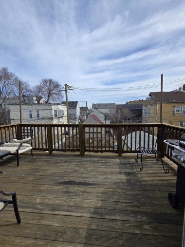 Enjoy fresh air and charming neighborhood views from this spacious wooden deck. Perfect for morning coffee or evening relaxation, the deck offers a serene retreat with ample space and a natural, rustic aesthetic that complements the outdoor setting.