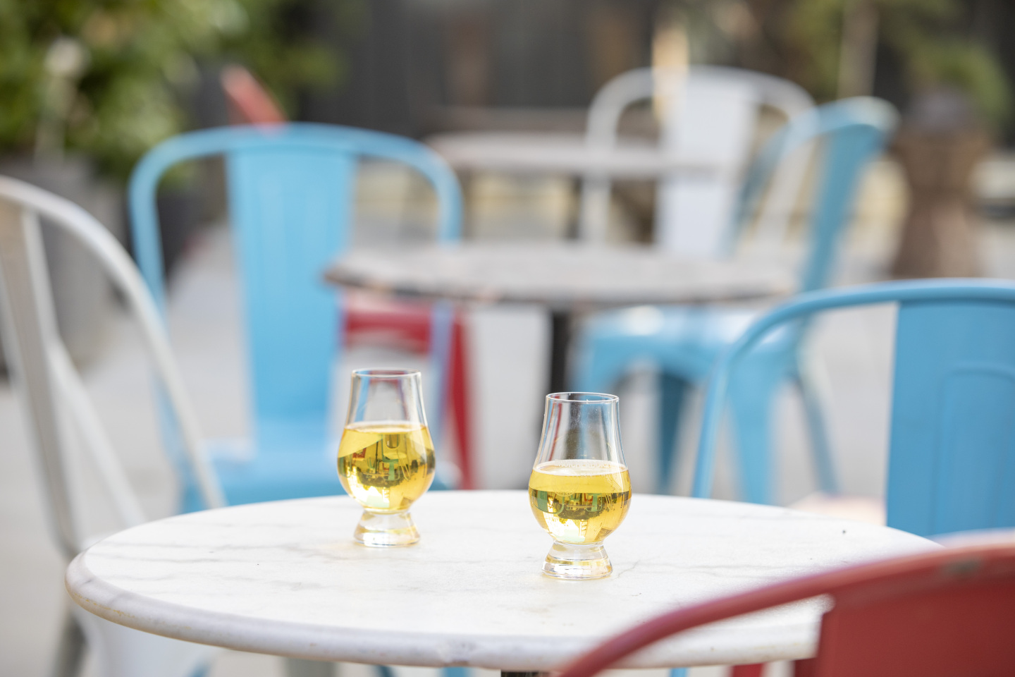 Two glasses of beer on a table outside