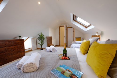 The large upper bedroom has a Super King double bed and also a single bed. The Super King bed can also be configured as two full-size single beds if required, giving guests the option of three single beds in this room.