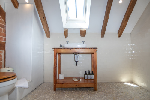 Bright upstairs bedroom with skylight, in-room sink and a modern wet-room featuring a relaxing rainfall shower — everything you need for a comfortable stay