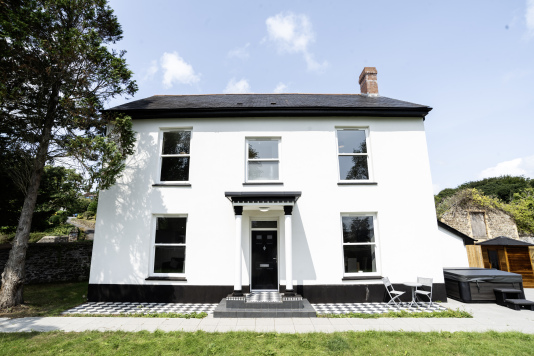 Generous front garden, stylish entrance and outdoor comforts including a hot tub, bistro seating and modern electric sauna