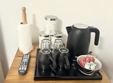 In each room: Microwave, plates, bowls, cutlery, tea, coffee, sugar, biscuits, kettle, mugs, drinking glasses