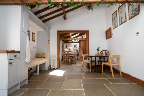Spacious open-plan farmhouse kitchen with full appliances, tea & coffee facilities, a warm AGA and dining space for everyone — seating for 8 including a bench and additional table seating