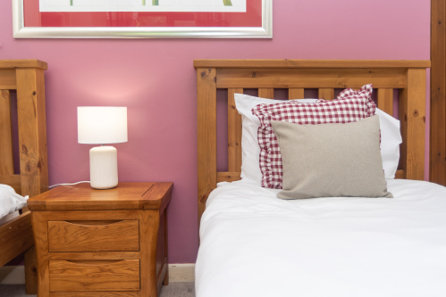 Our downstairs twin room is designed with comfort in mind, with warm lighting and gingham cushions finish it off 