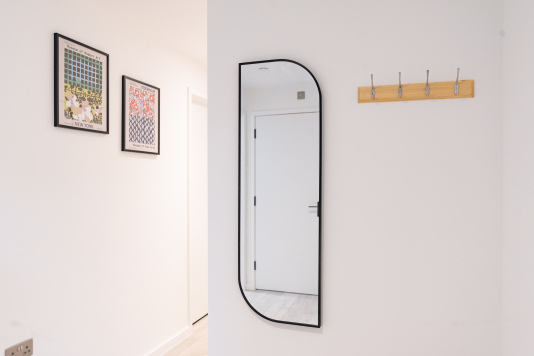 Welcoming entryway with coat hooks and full-length mirror.