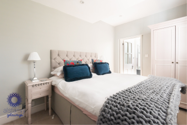 Comfortable king size bed leading to large bathroom