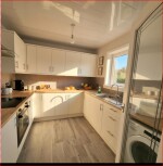 Kitchen with washing machine, microwave, kettle, oven and hob, fredge/freezer