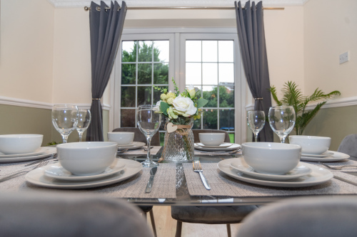 A bright, open and clean dining room with a table seating six, fully equipped with everything needed for home-from-home dining — perfect for family meals or unwinding after long workdays.