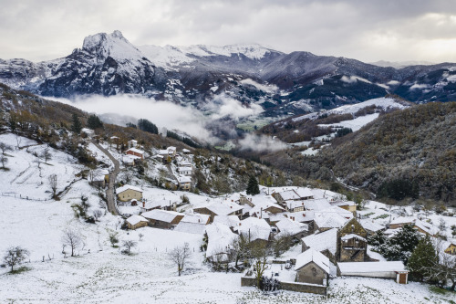 Pueblo de Colio, donde se encuentran los apartamentos los Picos de Europa, cubierto por la nieve. Al fondo el Valle de Liébana, Peña Ventosa y Peña Sagra