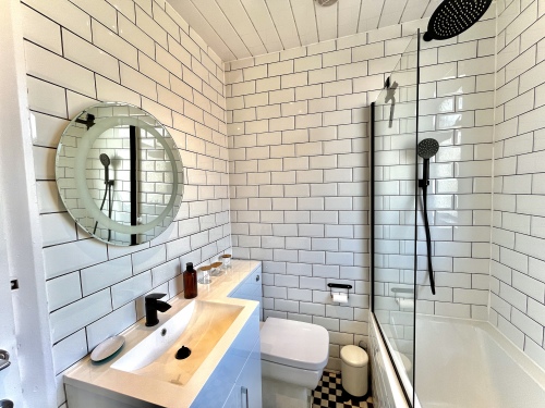 Bathroom -  Modern bath over shower combo, perfect for convenience and relaxation