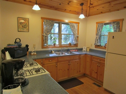 A bright and spacious kitchen is well appointed with dining and cookware, coffee, paper goods, more.