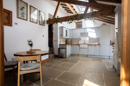 Spacious open-plan farmhouse kitchen with full appliances, tea & coffee facilities and a warm AGA ready for cooking on arrival