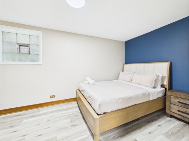 Bedroom Two — sun-washed and serene, with a refined corner seating nook.