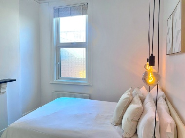 Bright double bedroom with natural light and feature lighting