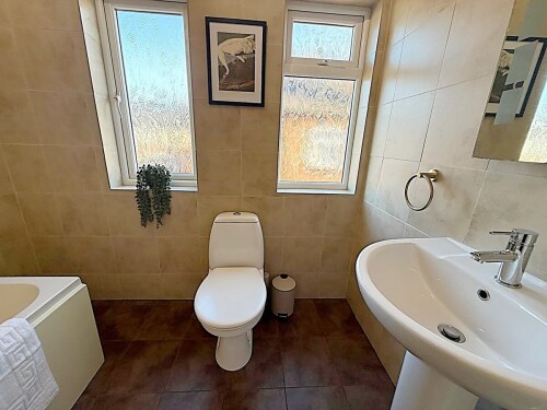 This modern full bathroom offers a shower over the bath, a sleek sink, and a toilet. With stylish finishes and a contemporary design, it’s the perfect place to relax and refresh.







