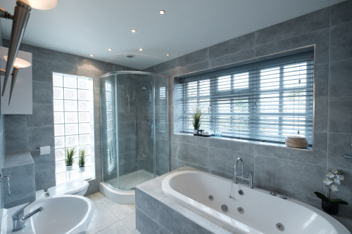 The fully tiled bathroom with a large, luxurious bath, separate shower enclosure, wash basin, heated towel rail and W.C.